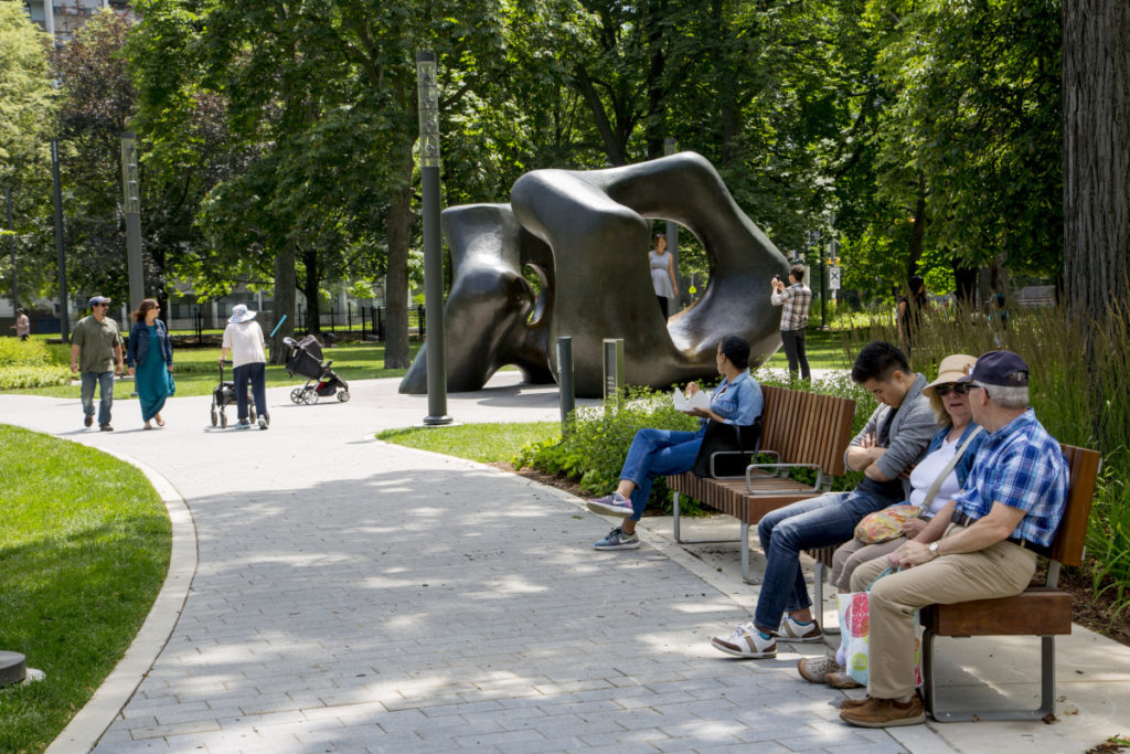 People enjoying the park, with Henry Moore's Large Two Forms in the background.